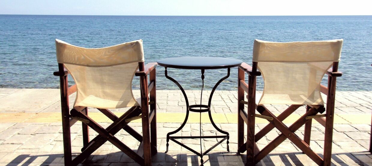 Zwei Stühle und ein runder Tisch am Meer
